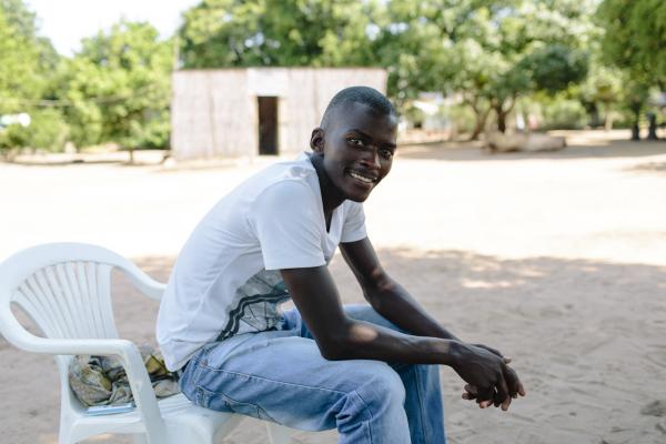 A young man sits outside as part of a sexual health discussion