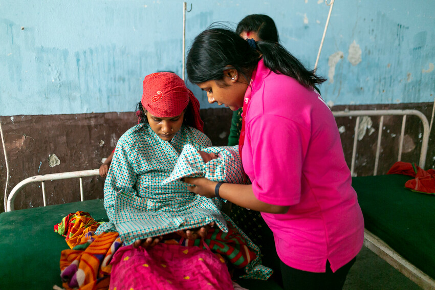 Manisha talks to a new mother in hospital