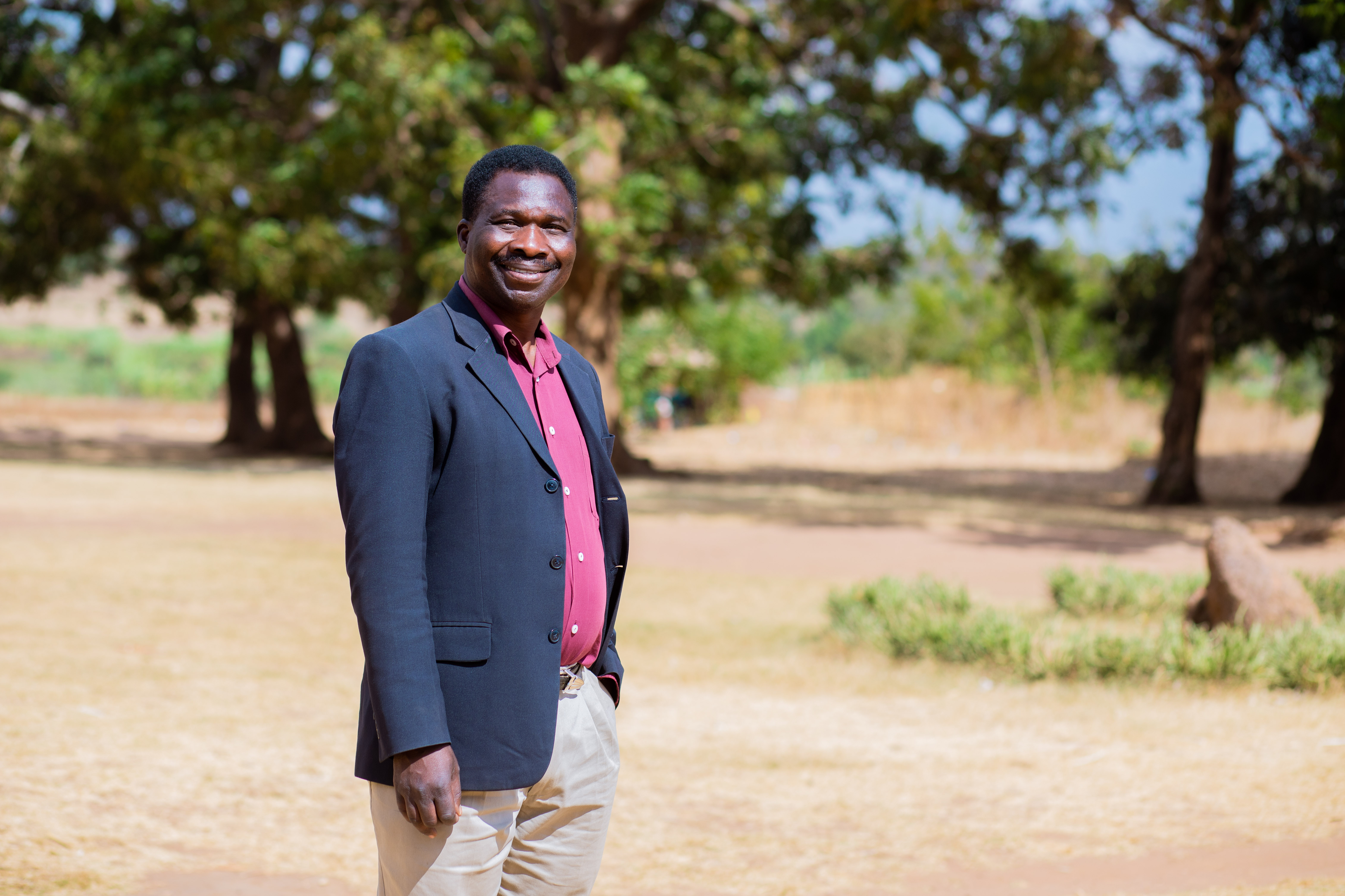 Theonas standing outside a school he volunteers at