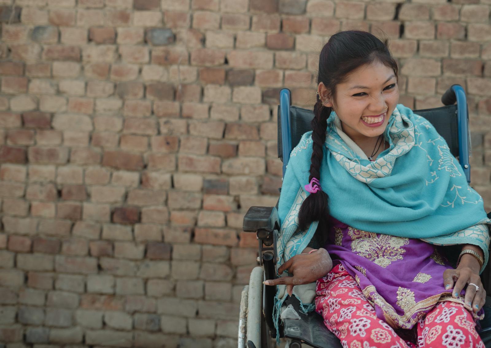 Rabina in her wheelchair given by a VSO volunteer
