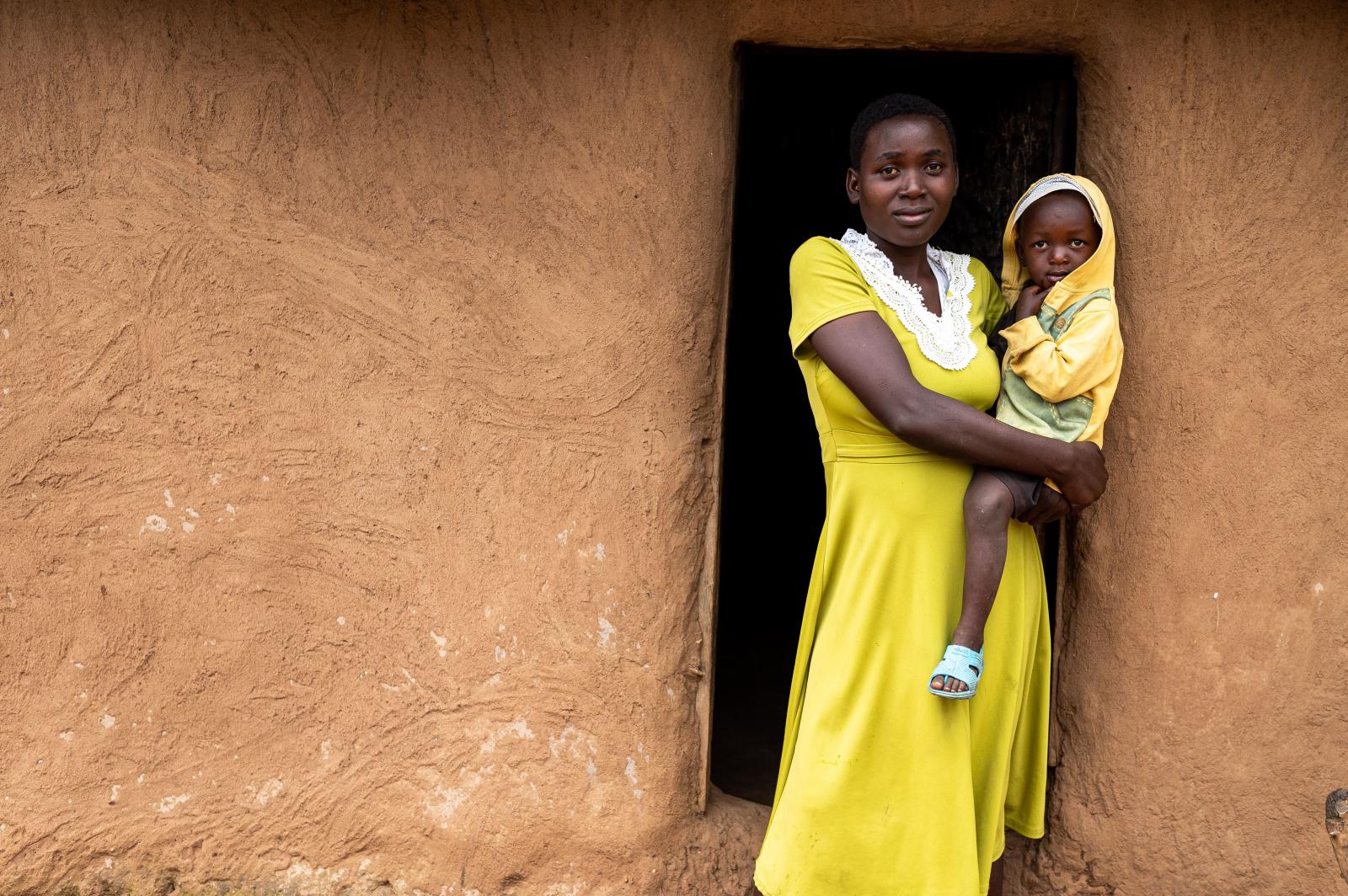 Girl in yellow dress holding a young child.