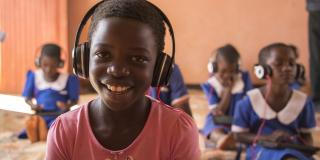 A student on the Unlocking Talent programme smiles as she works on her tablet in Mdzobwe Primary School