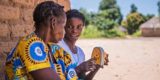 Youth teaching her mother about early marriages using a Talking Book