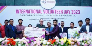 Dr Arman Hossain presenting a cheque in a group photo.