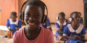 A student on the Unlocking Talent programme smiles as she works on her tablet in Mdzobwe Primary School