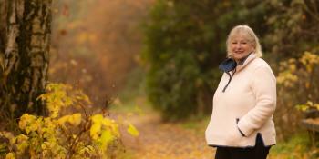 Volunteer Carol Carson walks in woodland in Scotland 