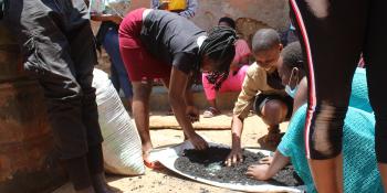 Women and youth making briquettes for fuel. Uganda.