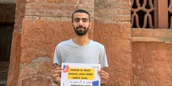 Awais holding a sign supporting ending child labour