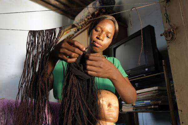 Merenciana, who learned her skills whilst in prison, braids hair at her home