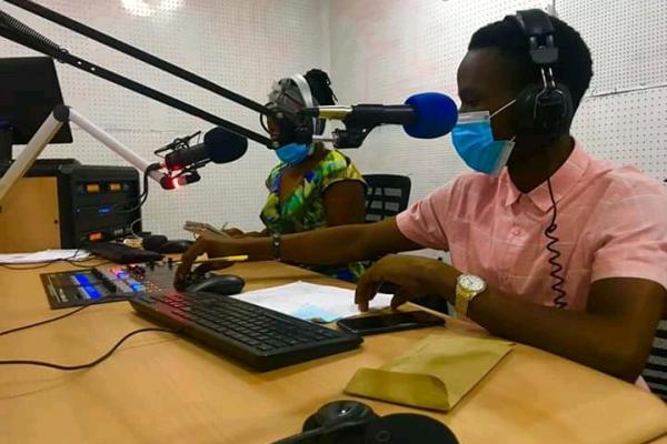 two people with radio microphones and wearing masks