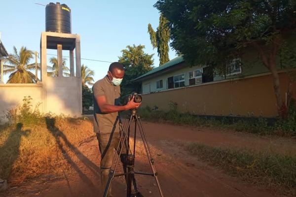 Nicholaus Ambwene filming in a mask