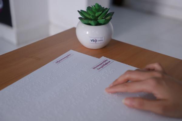 Close up of a woman's hand reading braille