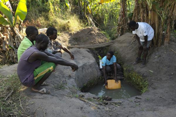 Volunteers showing community members how to purify the water in the well by using chlorophyll after Cyclone Idai.