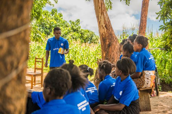 community volunteer using a Talking Book to deliver a lesson to the students.