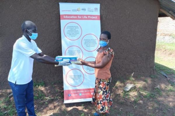 Paul giving a hygiene kit to a student