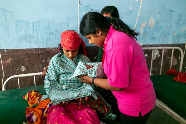 VSO volunteers counselling a new mother regarding her reproductive health.