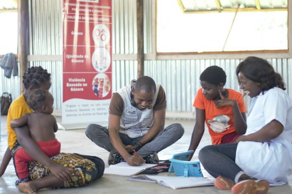 Volunteer Adérito helps with a literacy session