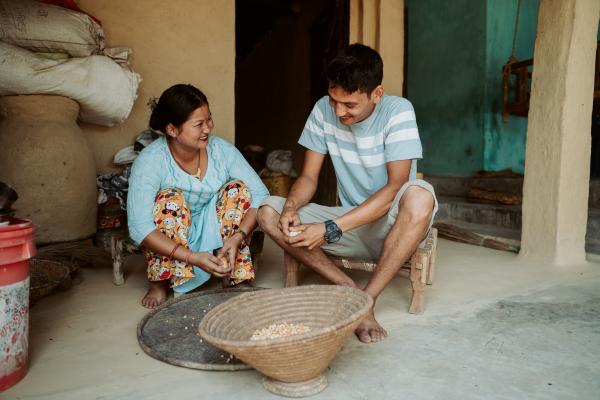 A smiling couple prepare food together