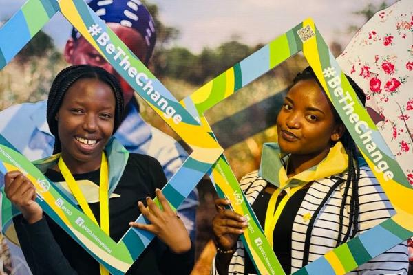 Women pose at the #BeTheChange photobooth