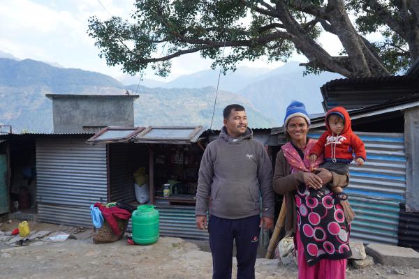 Sita and Surendra stand outside their home