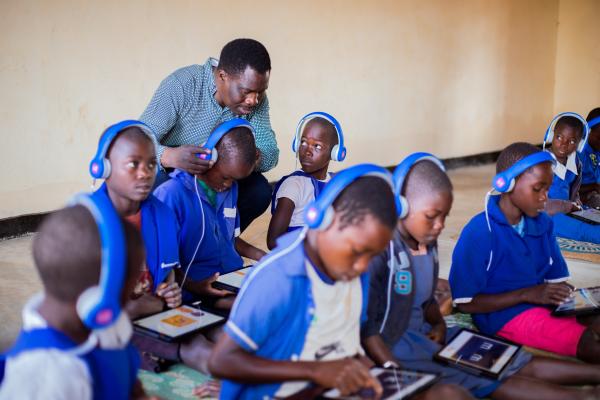 Students with headsets on, learning on educational tablets. 