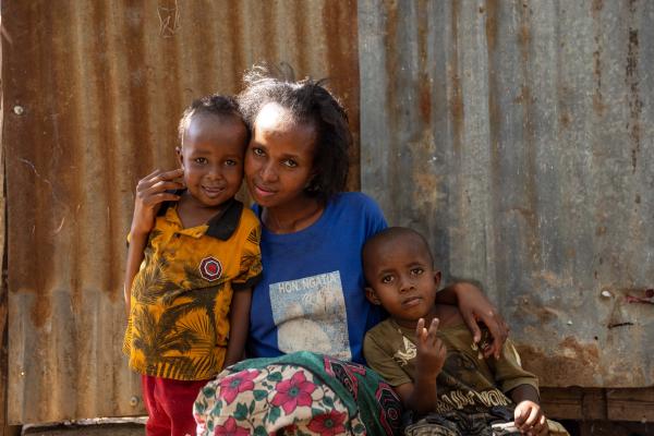 Elizabeth, waste picker, with her two children at her home