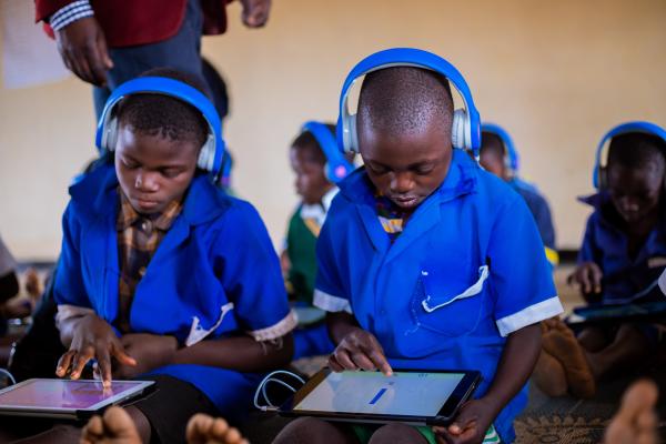 Student Thoko using an educational tablet, with a headset on, in the learning centre.