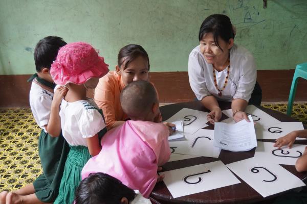 Aye Mya Mya helping children in the classroom