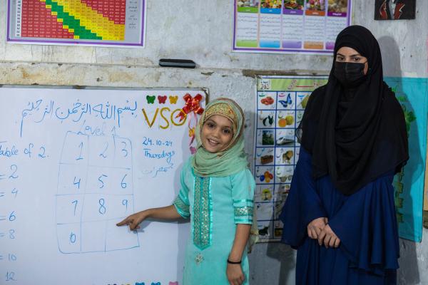 Happy child with volunteer in class