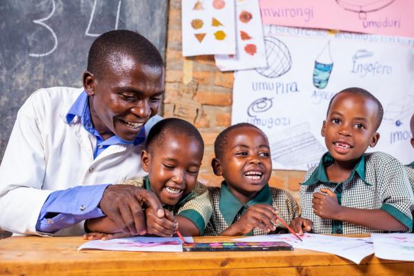 Teacher helps children learn letters.