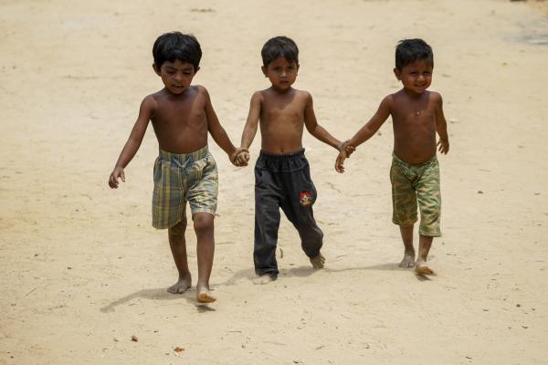 Three Rohingya children walk in the hillock of the Balukhali extension camp, Cox's Bazar, Bangladesh.