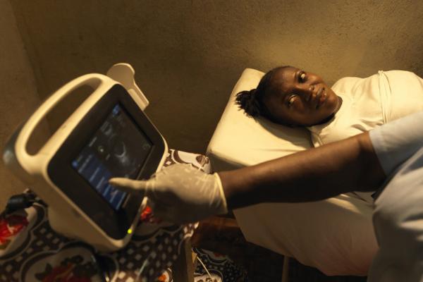 Mamie Momoh, 21, who is nine months pregnant, observes as she is scanned for the first time at Kamaranka Community Health Centre